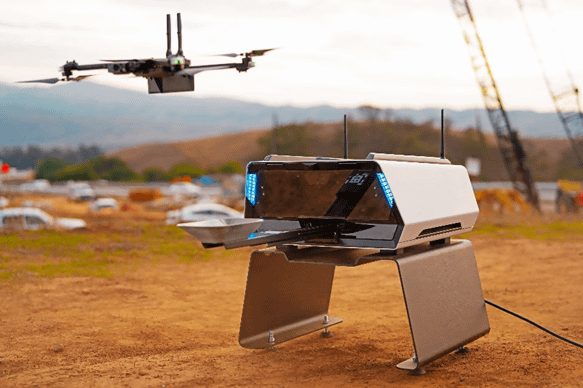 写真：自動充電ポート付きドローン「Skydio Dock for X2」。ドックとその近くを飛行するドローン。