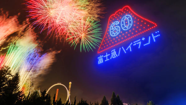 写真：夜空に打ち上がる花火と、ドローンの光で表現された60周年を記念したロゴマーク