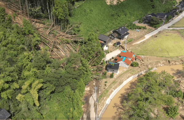 写真：土砂崩れが起きている山の斜面と道路の様子
