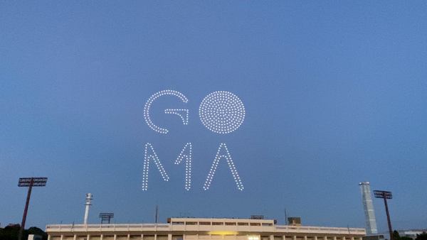 写真：ドローンショーの様子。ドローンの光によって空に表現された「GOMA」。