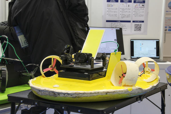 写真：展示された黄色いボディの「カメラ搭載式ボート型ドローン」