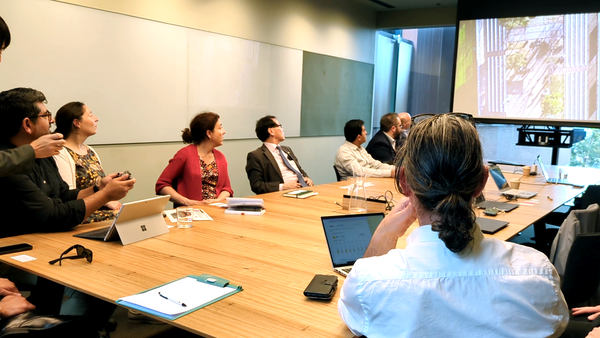 写真:室内でモニターの映像を見る人々