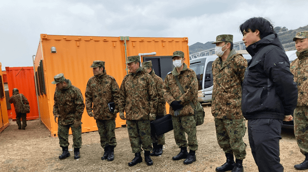 写真：複数の団員が視察する様子