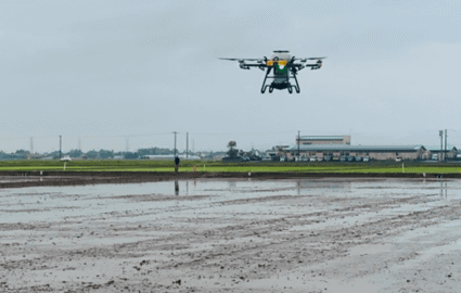 写真：田んぼの上をドローンが飛行する様子