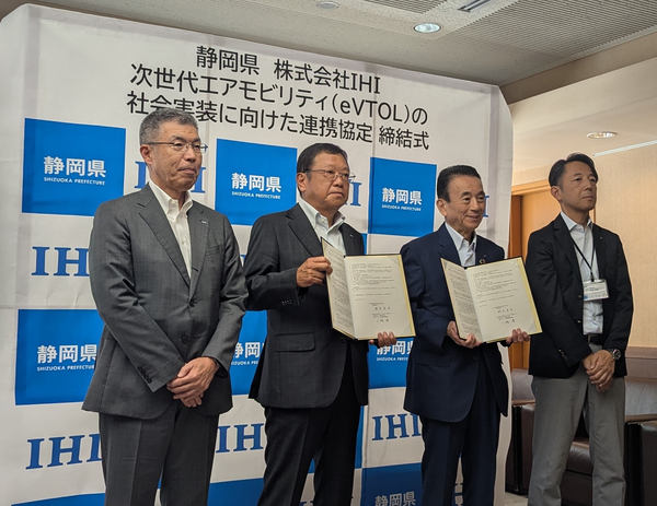 写真：締結式の様子。横並びの4人、中央の2人はそれぞれ協定書を手にしている