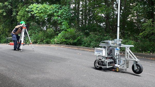 写真：測量する作業員とスタッフィー