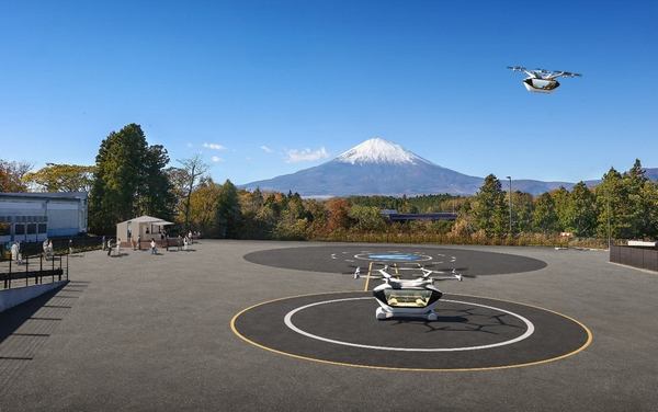 富士山が見えるバーティポートでスタンバイする空飛ぶクルマ、飛行する空飛ぶクルマのイメージ