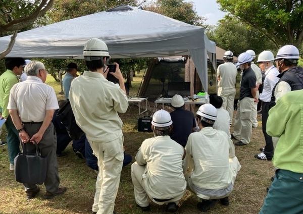 写真：屋外に設置したテント周辺に集まる関係者