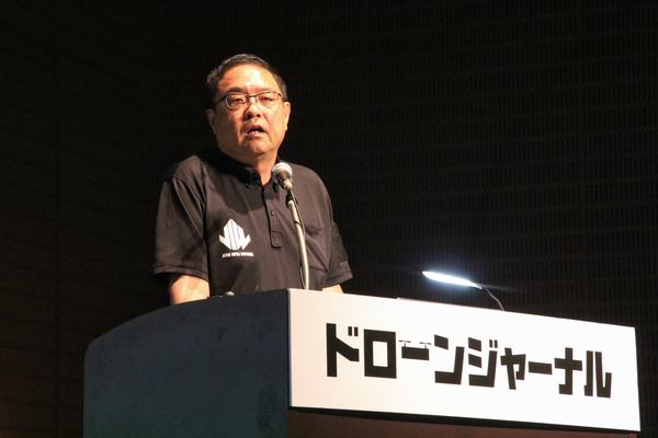写真：壇上で話をする岡田氏