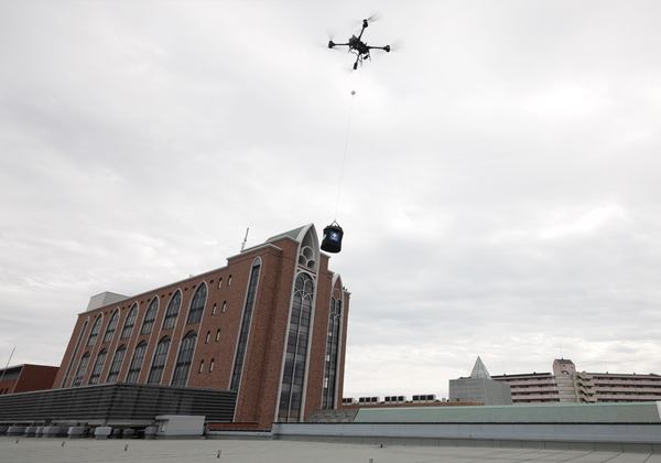 写真：荷物を吊り下げて飛行するドローン