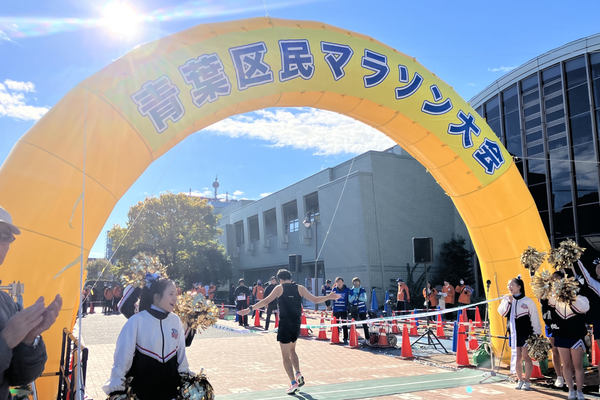 写真：青葉区民マラソン大会のゴール地点でテープをきるランナー