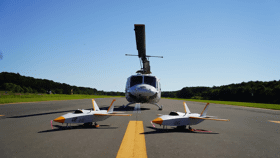 写真：滑走路に並ぶ2機の無人実験機とヘリコプター
