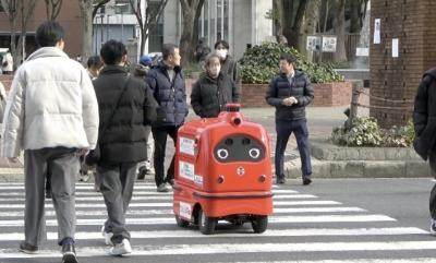 写真：通行人とともに歩道をわたるロボット