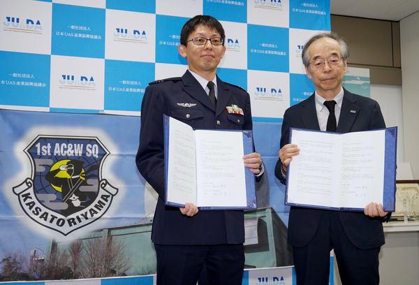 写真:協定書を手にする2人