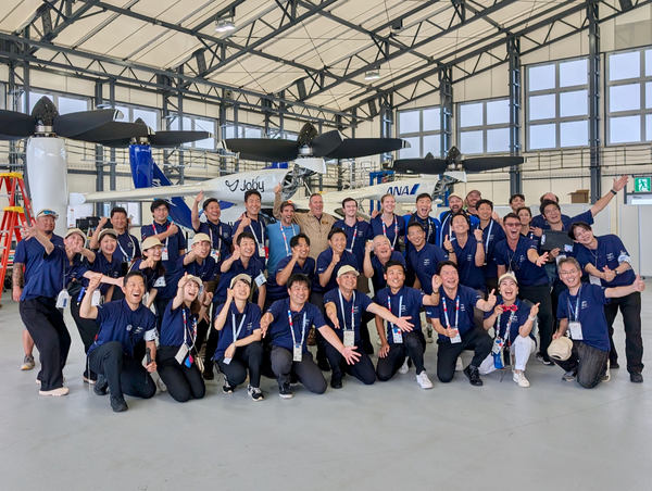 写真:空飛ぶクルマ「Joby S4」と関係者たちの集合写真