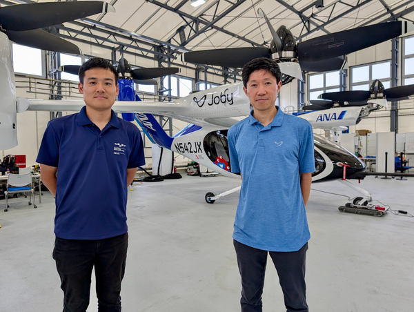 写真:格納庫の「Joby S4」を背景に横並びになる2人