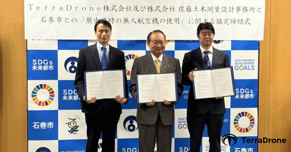 写真：Terra Drone株式会社及び株式会社佐藤土木測量設計事務所と石巻市との「熊出没時の無人航空機の使用」に関する協定締結式、協定書を手にして並ぶ3人