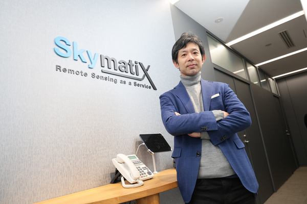 写真：スカイマティクスのエントランスで腕組みをする渡邉氏