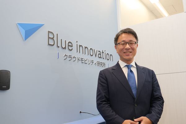 写真:ブルーイノベーション クラウドモビリティ研究所の入り口に立つ熊田雅之氏