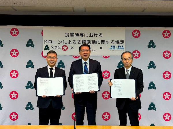 写真：協定書を手にする3人