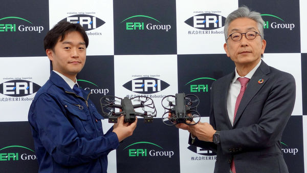 写真:ドローンを手に持ち並ぶ2人