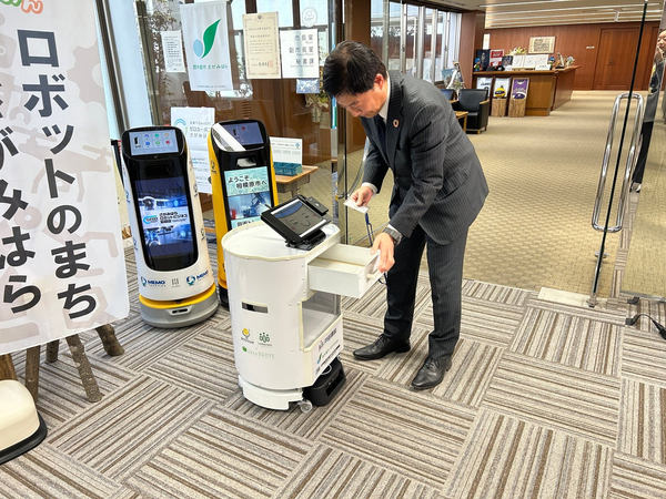 写真:職員がロボットの引き出しを開ける様子