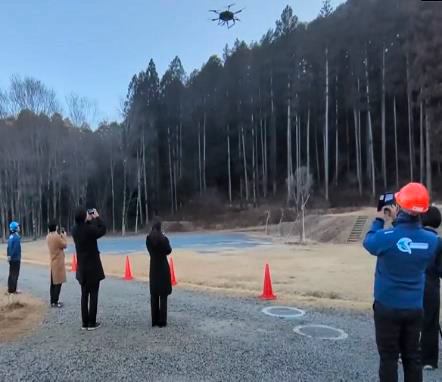 写真：飛行するドローンと、それを見守るスタッフ