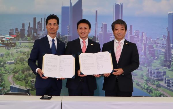 写真:合意書を手にした3人