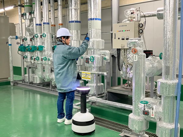 写真：人とロボットが設備を点検する様子