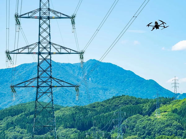 写真：送電線に沿って飛行するドローン