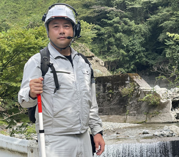 写真：川を背景にした中田氏