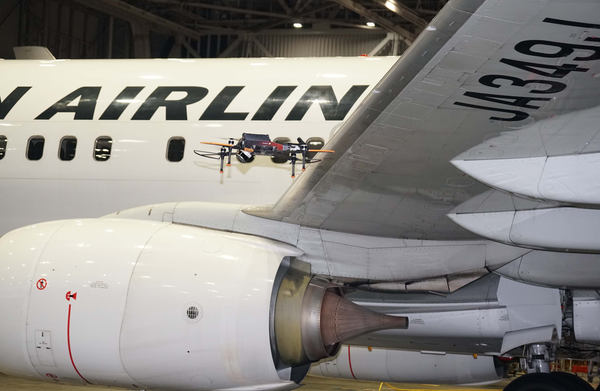 写真：航空機の翼の近くを飛行するドローン
