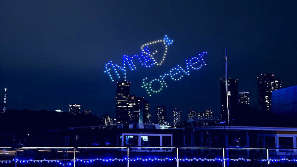 写真:ドローンショーで夜空に描かれたメッセージ「flying forever」とアジフライモチーフ