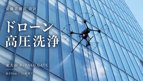写真:飛行するドローンがガラスの外壁に向かって水を噴射する様子